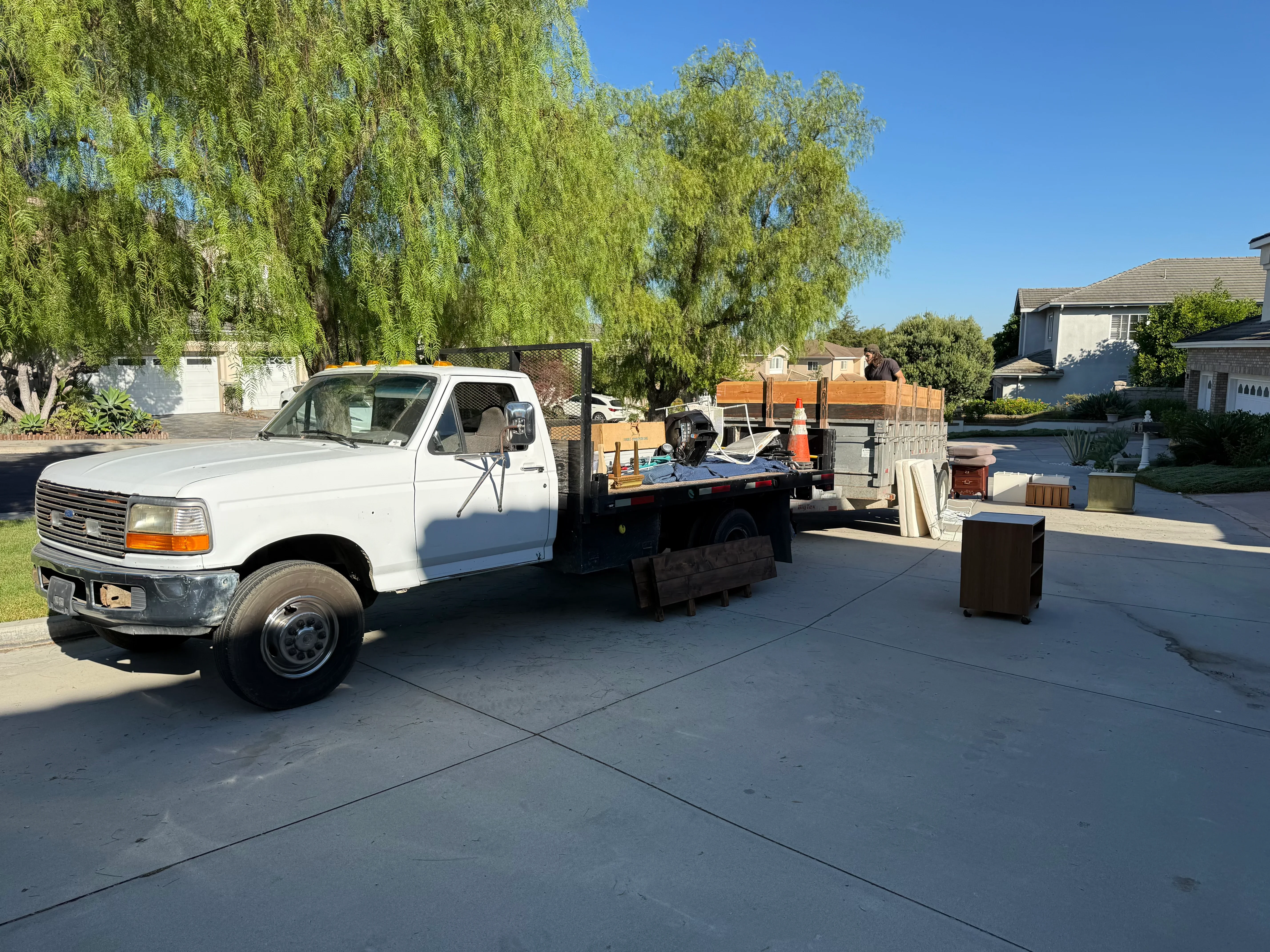 Flatbed truck loaded with wooden pallets, metal bins, and mixed debris during residential junk removal